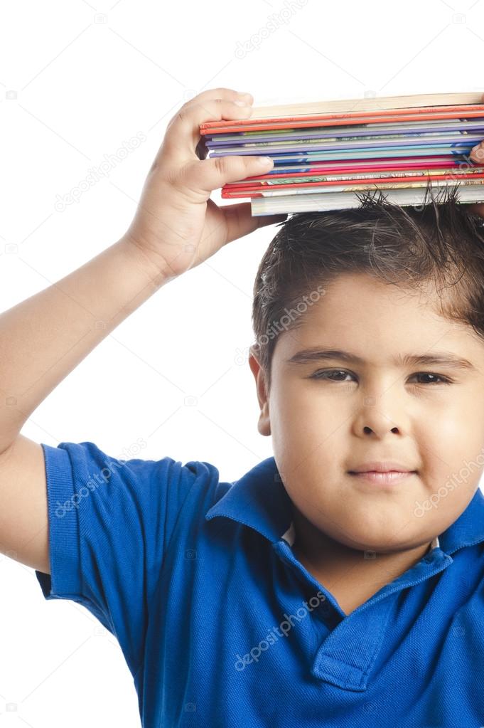 Boy holding a stack of books over his head