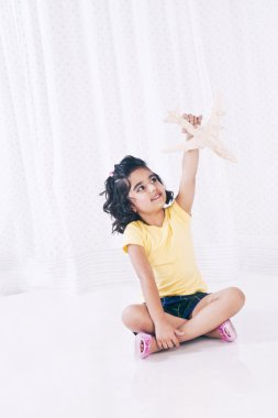 oyuncak uçak ile oynayan kız