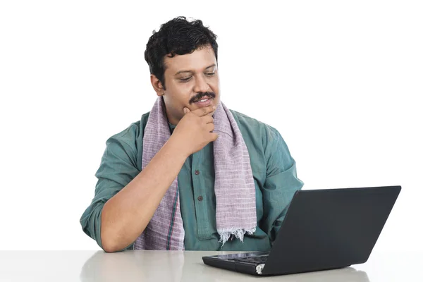 Man looking at a laptop and thinking — Stock Photo, Image