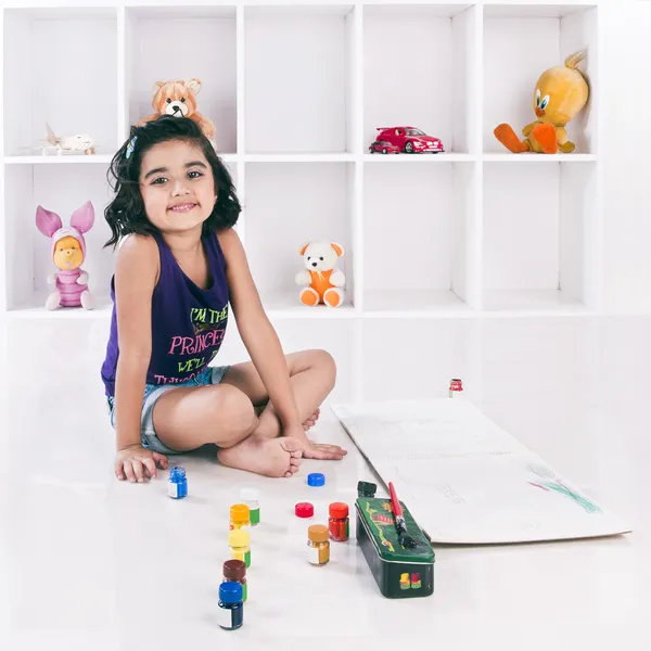 Portrait of a girl sitting on the floor and smiling — Stock Photo, Image