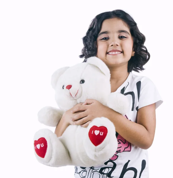 Retrato de una niña sosteniendo un osito de peluche y sonriendo — Foto de Stock