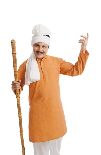 Portrait of a man holding wooden staff and gesturing — Stock Photo, Image