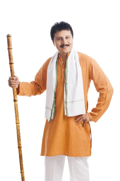 Portrait of a man holding wooden staff and smiling — Stock Photo, Image