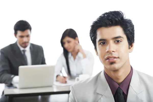 Retrato de un hombre de negocios con sus colegas de fondo — Foto de Stock