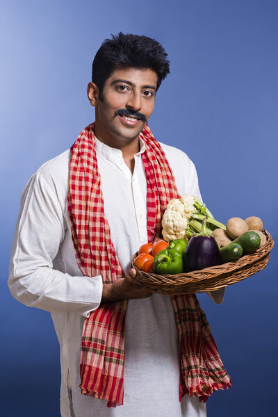 Portrait of a man carrying basket of vegetables