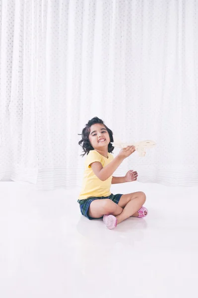 Menina brincando com avião de brinquedo e sorrindo — Fotografia de Stock
