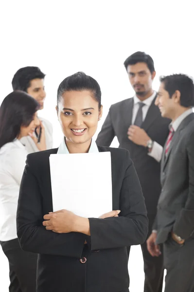 Портрет деловой женщины, улыбающейся с коллегами на заднем плане — стоковое фото