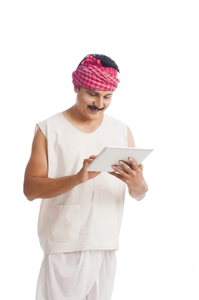 Farmer using a digital tablet and smiling — Stock Photo, Image