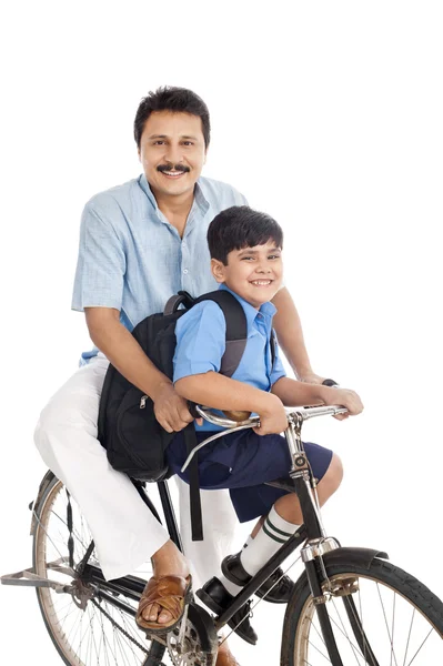 Человек с сыном на велосипеде — стоковое фото