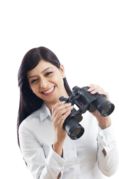 Retrato de uma mulher de negócios segurando binóculos e sorrindo — Fotografia de Stock