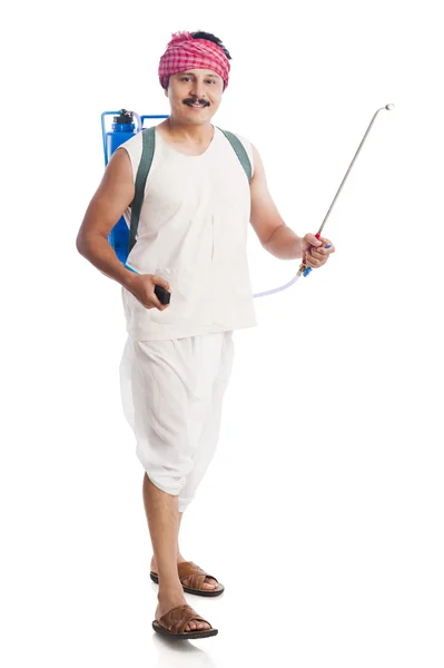 Portrait of a farmer carrying a crop sprayer and smiling — Stock Photo, Image