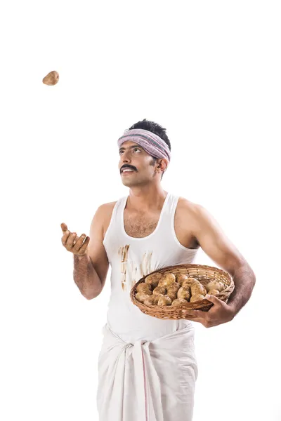 Farmer tossing a potato — Stock Photo, Image