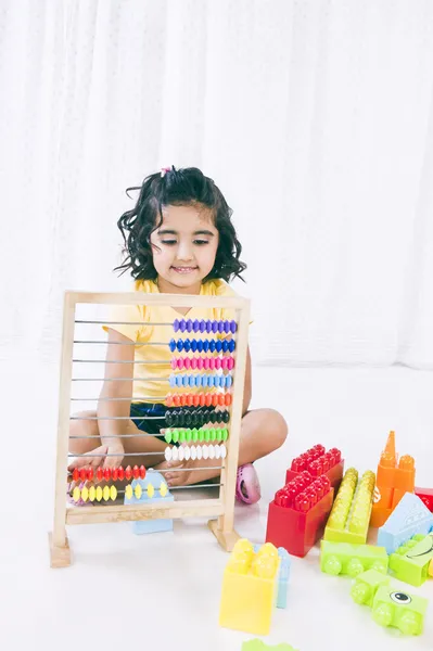 Chica jugando con ábaco y bloques de construcción —  Fotos de Stock