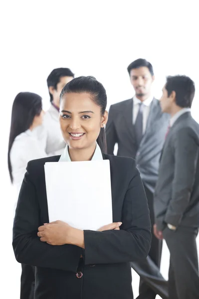 Retrato de una mujer de negocios sonriendo con sus colegas de fondo — Foto de Stock