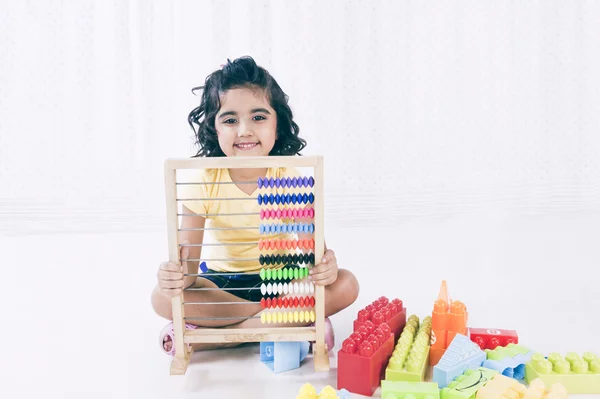 Retrato de una chica jugando con ábaco y sonriendo — Foto de Stock