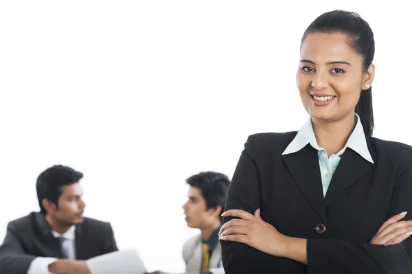 Retrato de una mujer de negocios sonriendo con sus colegas de fondo — Foto de Stock