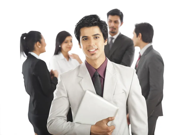 Portrait of a businessman smiling with his colleagues in the background — Stock Photo, Image