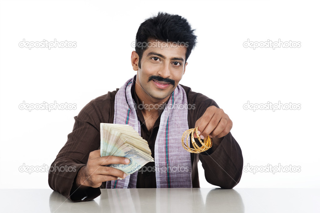 Portrait of a man holding money and golden bangles