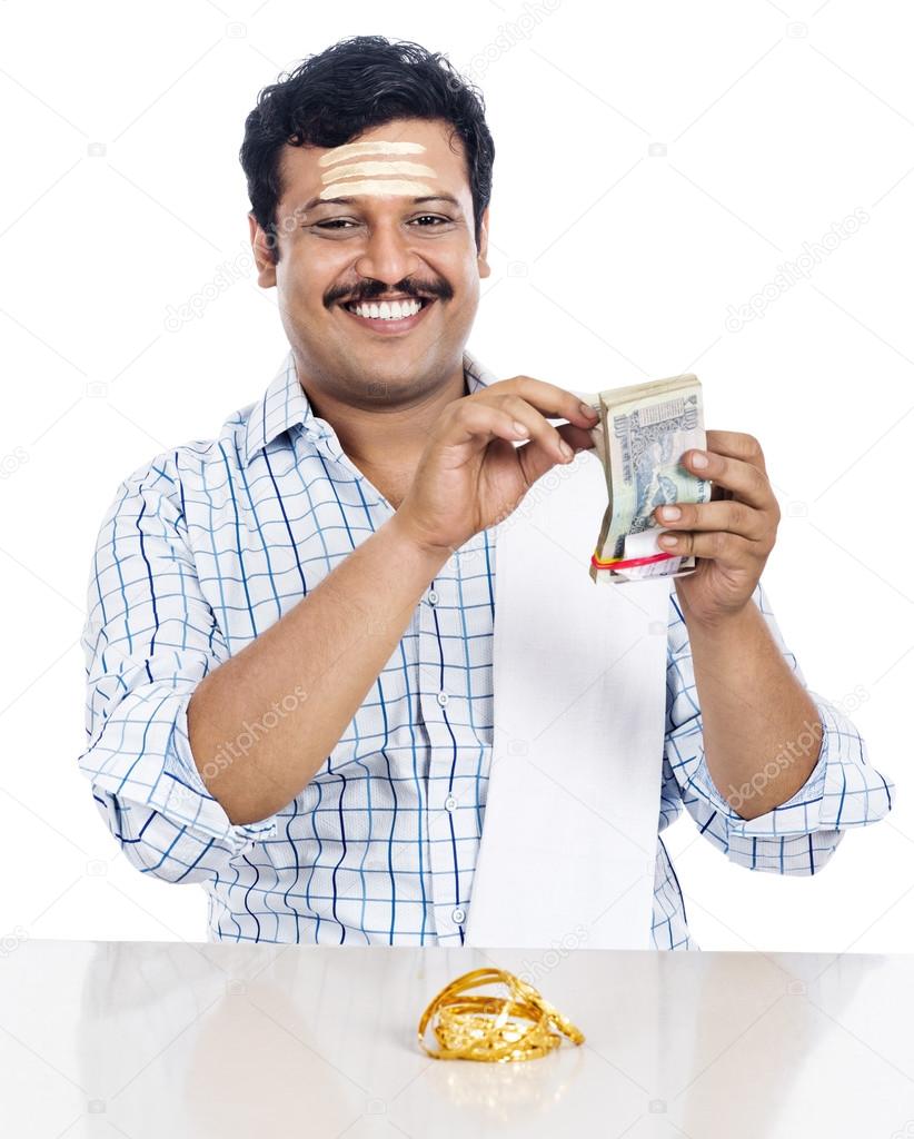 Portrait of a South Indian man counting money and smiling