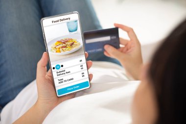 Kadınlar evlerinde cep telefonu akıllı telefonları kullanarak internetten yemek siparişi verdiklerini doğruladılar. Restorandan eve kadar akıllı telefon siparişi veren kişi. konsept
