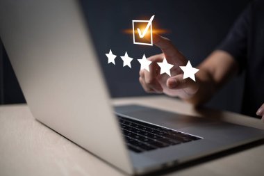 Satisfaction and customer service survey concept, business people using  laptop. to answer the questionnaire And the satisfaction rating, the satisfaction rating with the smiley face icon 5 stars.