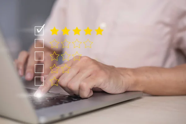 Satisfaction and customer service survey concept, business people using  laptop. to answer the questionnaire And the satisfaction rating, the satisfaction rating with the  icon 5 stars.