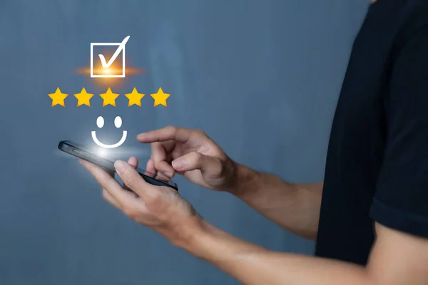 Satisfaction and customer service survey concept, business people using  smartphone. to answer the questionnaire And the satisfaction rating, the satisfaction rating with the smiley face icon 5 stars.