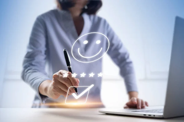 Satisfaction and customer service survey concept, business people using  laptop. to answer the questionnaire And the satisfaction rating, the satisfaction rating with the smiley face icon 5 stars.