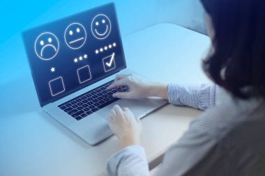 Memnuniyet ve müşteri araştırma konsepti, iş adamları dizüstü bilgisayar kullanıyor. Ankete cevap vermek için ve memnuniyet derecesi, gülen surat ikonu ile memnuniyet derecesi 5 yıldız.