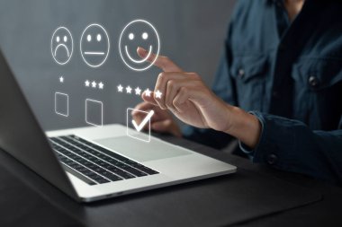 Memnuniyet ve müşteri araştırma konsepti, iş adamları dizüstü bilgisayar kullanıyor. Ankete cevap vermek için ve memnuniyet derecesi, gülen surat ikonu ile memnuniyet derecesi 5 yıldız.