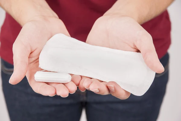 Jovem segurando almofada menstrual e tampão — Fotografia de Stock