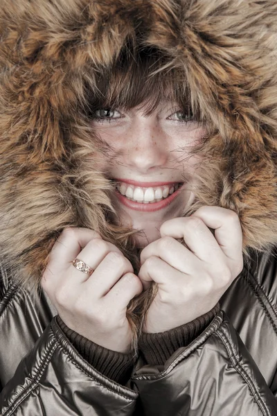 Jovencita vistiendo abrigo de invierno calentándose — Foto de Stock