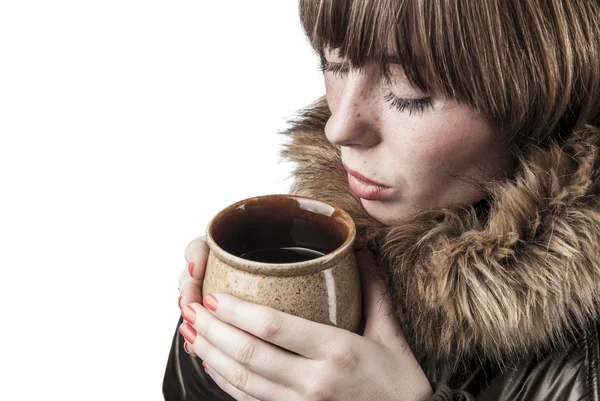 Chica joven con abrigo de invierno calentándose con una taza de té caliente — Foto de Stock