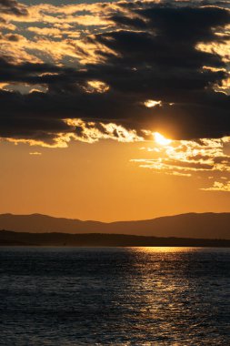 Hırvatistan kıyısındaki dağların üzerinde gün batımı. Akdeniz 'de bir yaz sahnesi.