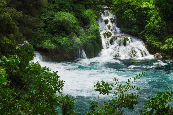 Yaz aylarında doğal bir ormanda turkuaz suyla Idyllic şelalesi.