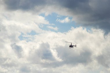Gökyüzündeki rahatsız bulutlar bir helikopterle geçer..