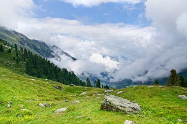 Bulutların üstünde yüksek dağların arasında Alplerin zirveleri arasında.
