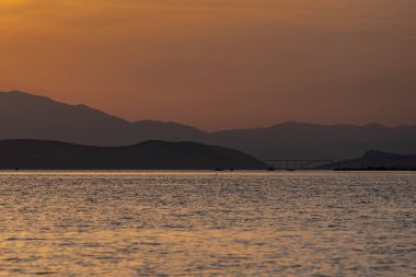 Silhouettes of boats in front of the bridge to Krk. Scene from Croatia.