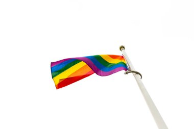 Gökkuşağı LGBT bayrağını yakın çekimde parlak beyaz bir gökyüzüne doğru dalgalanıyor. Suffolk Gururu. Mutluluk kavramı. Özgürlük. Eşcinsel çift.