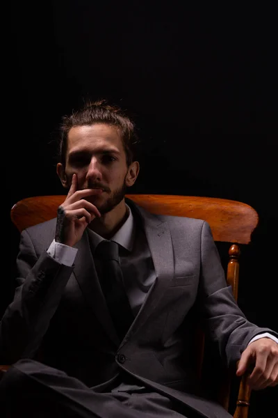 Ein Junger Geschäftsmann Schicken Grauen Anzug Sitzt Einem Hölzernen Sessel — Stockfoto