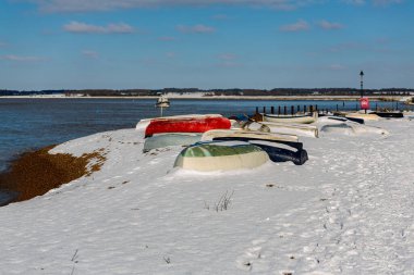 Ters dönmüş sandallar Suffolk sahilindeki plaja demirlemiş. Nadir görülen bir kar fırtınasının ardından karla kaplandılar.