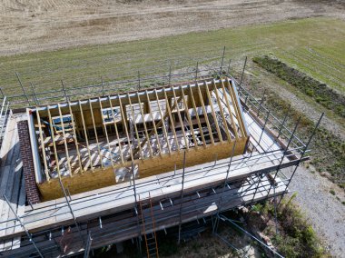 Bitmemiş bir ahır dönüşümünün havadan görüntüsü. Yapıyı çevreleyen iskeleler var.