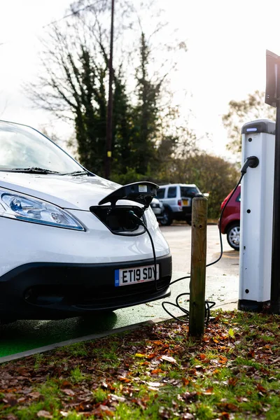Woodbridge Suffolk UK 28 Kasım 2021: Nissan E-NV200 elektrikli minibüs Suffolk, İngiltere 'de halka açık bir otoparkta şarj ediliyor