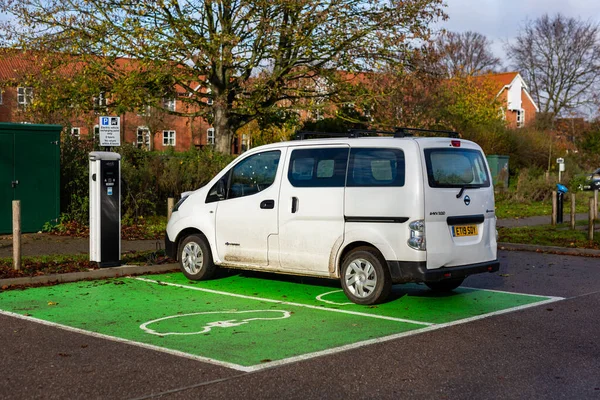 Woodbridge Suffolk UK 28 Kasım 2021: Nissan E-NV200 elektrikli minibüs Suffolk, İngiltere 'de halka açık bir otoparkta şarj ediliyor