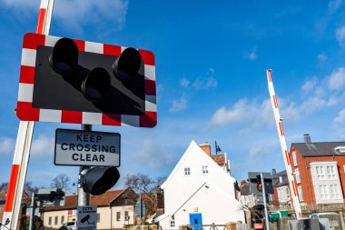 Londra 'ya giden ana hatta yoğun bir geçitten açık işaret vermeye devam edin. Trenler geçerken halkı bilgilendirmek ve güvende tutmak için bariyerler ve uyarı ışıkları var.