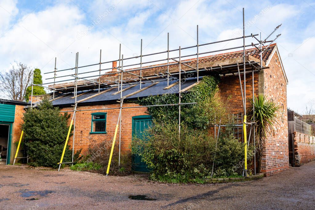 Scaffolding and roof repairs, replacing roof tiles on a town house in a small Suffolk town
