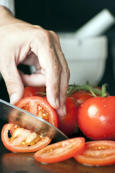 Chef mão e faca cortando tomate — Fotografia de Stock