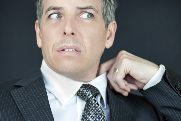 Worried Businessman Adjusts Collar