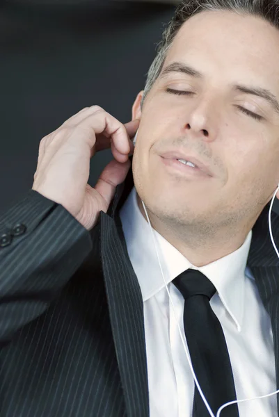 Serene Businessman Adjusts EarBud — Stock Photo, Image