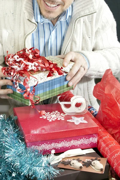 Usmívající se muž balení dárků — Stock fotografie